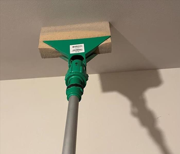 pole with sponge cleaning white ceiling