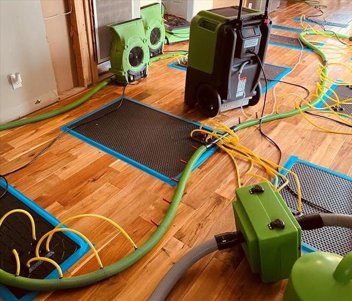 green machines with hoses on light brown wood floor